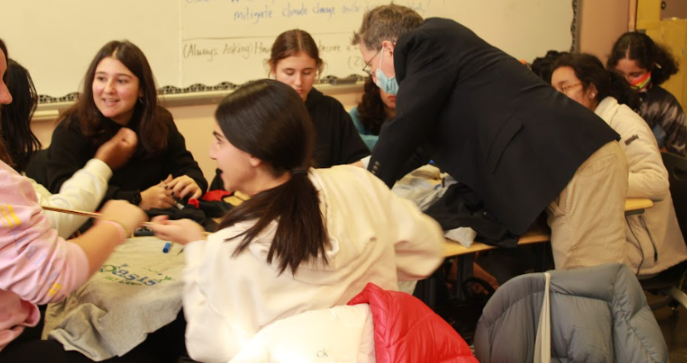 Mr. Zaid helping students make t-shirt tote bags. (courtesy of yearbook)