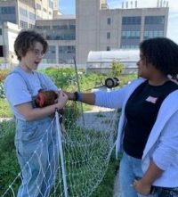 Marly Regalado, right, pets a chicken on the rooftop farm.