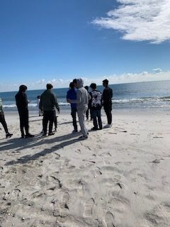 Students at Lido Beach, NY, writer wearing gray hoodie.